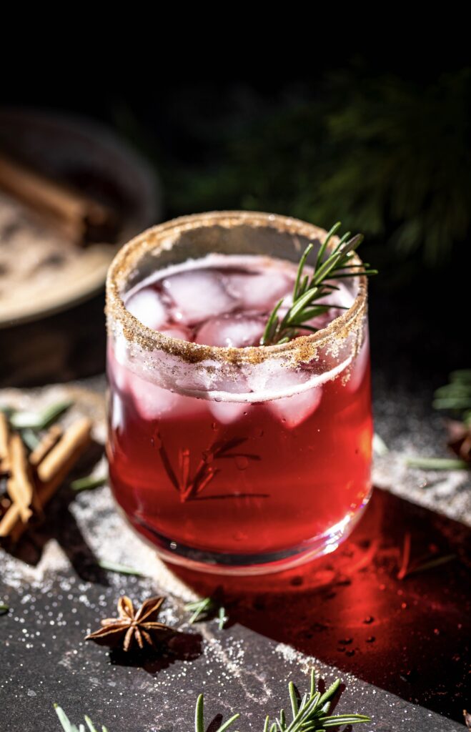 glass of the quick and easy sparkling cranberry mocktail with cinnamon sugar rim