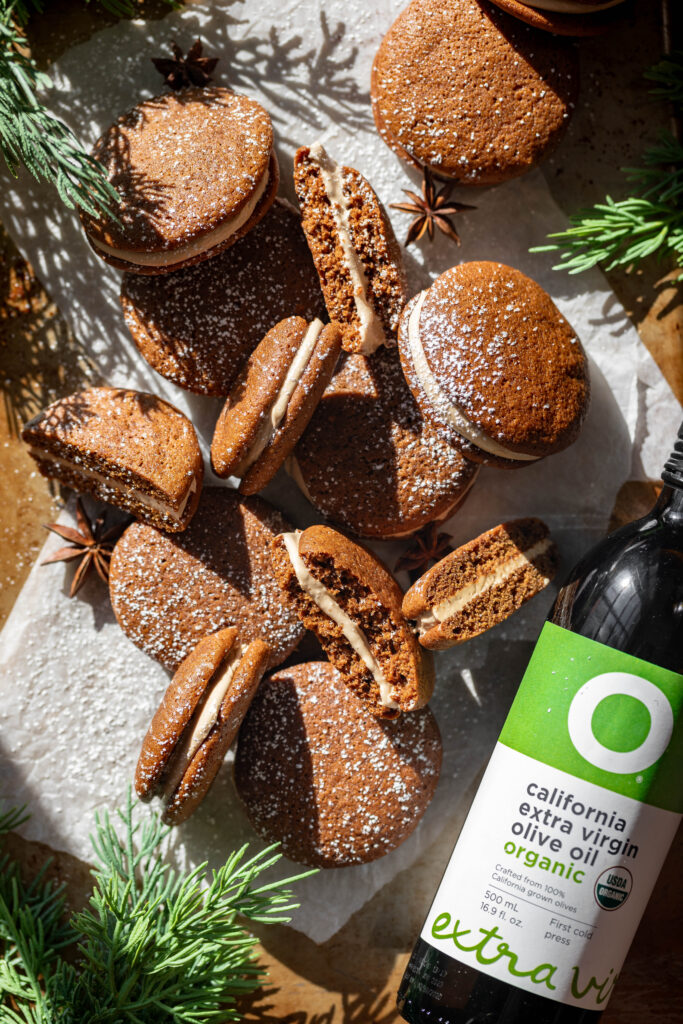 gingerbread latte whoopie pies with powdered sugar on top and a bottle of the olive oil used